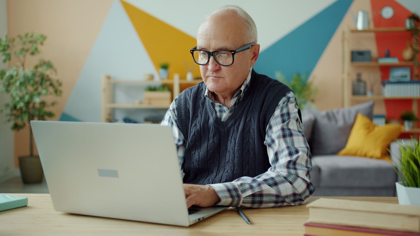 Homme âgé utilisant un ordinateur portable dans un bureau à domicile