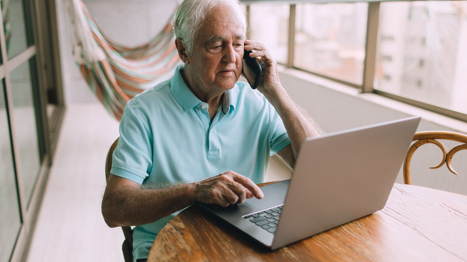Homme consultant un ordinateur portable et un téléphone avant d'envoyer des documents en ligne