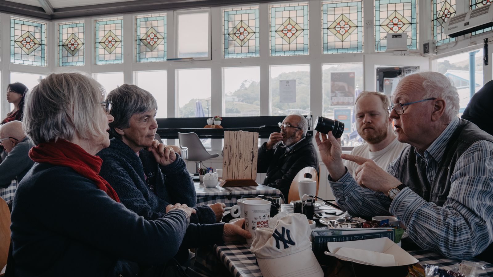 Groupe d'adultes réunis autour d'une table de café pour discuter