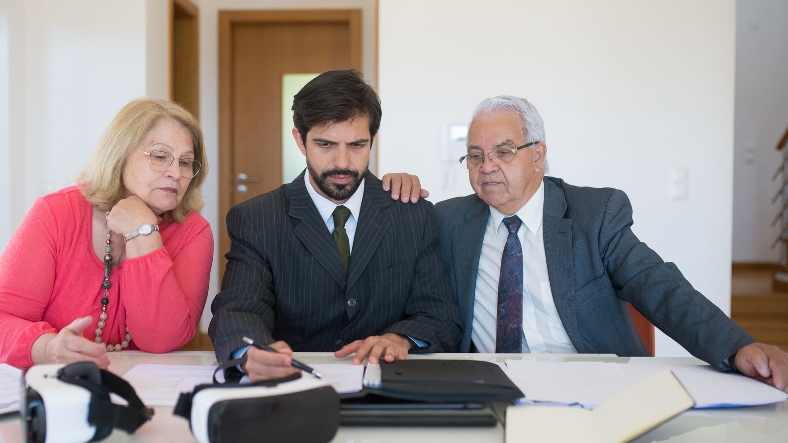 Couple relisant des documents immobiliers avec une conseillère autour d'une table