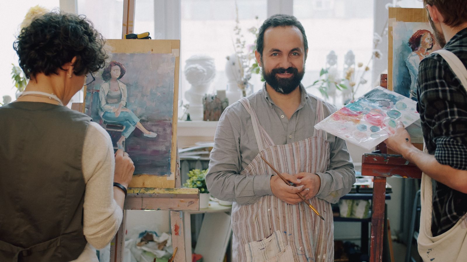 Adultes peignant ensemble dans un atelier lumineux
