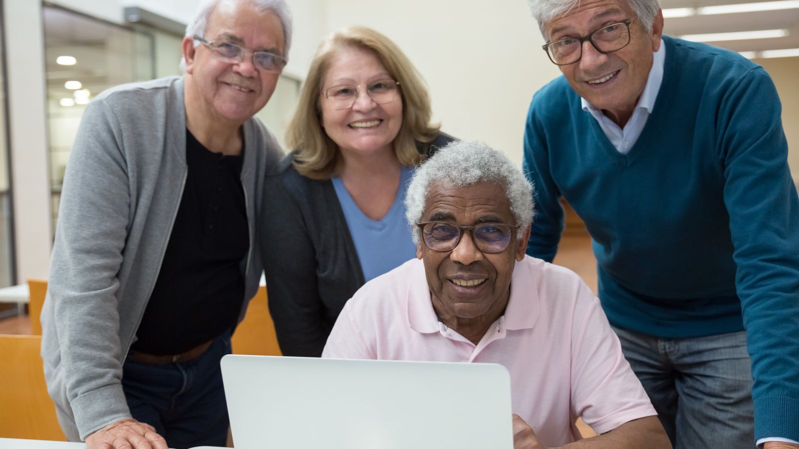 Adultes en atelier de formation utilisant des ordinateurs portables autour d'une table